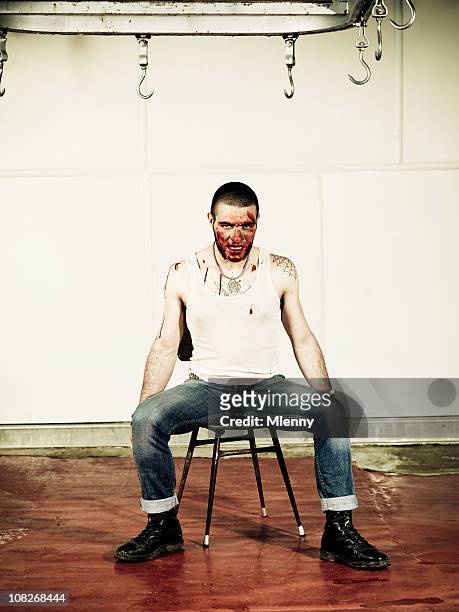 man covered with blood and sitting in slaughterhouse - slaughterhouse stock pictures, royalty-free photos & images