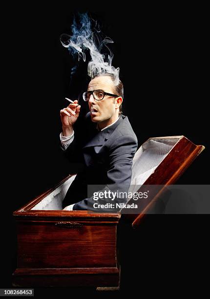 man smoking cigarette in a coffin - inside coffin stock pictures, royalty-free photos & images