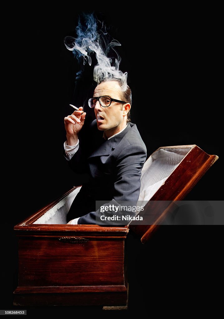 Homem fumar cigarro em Caixão