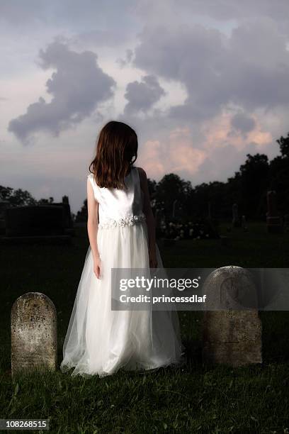 little girl wearing white dress in graveyard - girl white dress stock pictures, royalty-free photos & images