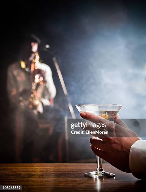 mann hält martini - blues in the night stock-fotos und bilder