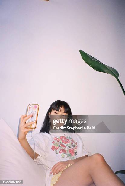 portrait of young woman taking a selfie on phone. - body positivity stock-fotos und bilder