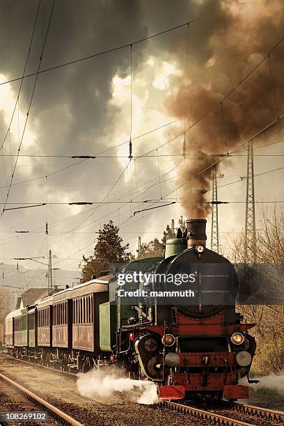 old locomotive leaving the railway station - locomotive stock pictures, royalty-free photos & images