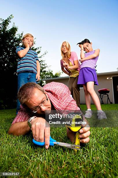 sorgfältige vater mähen auf dem rasen mit schere - mowing lawn stock-fotos und bilder