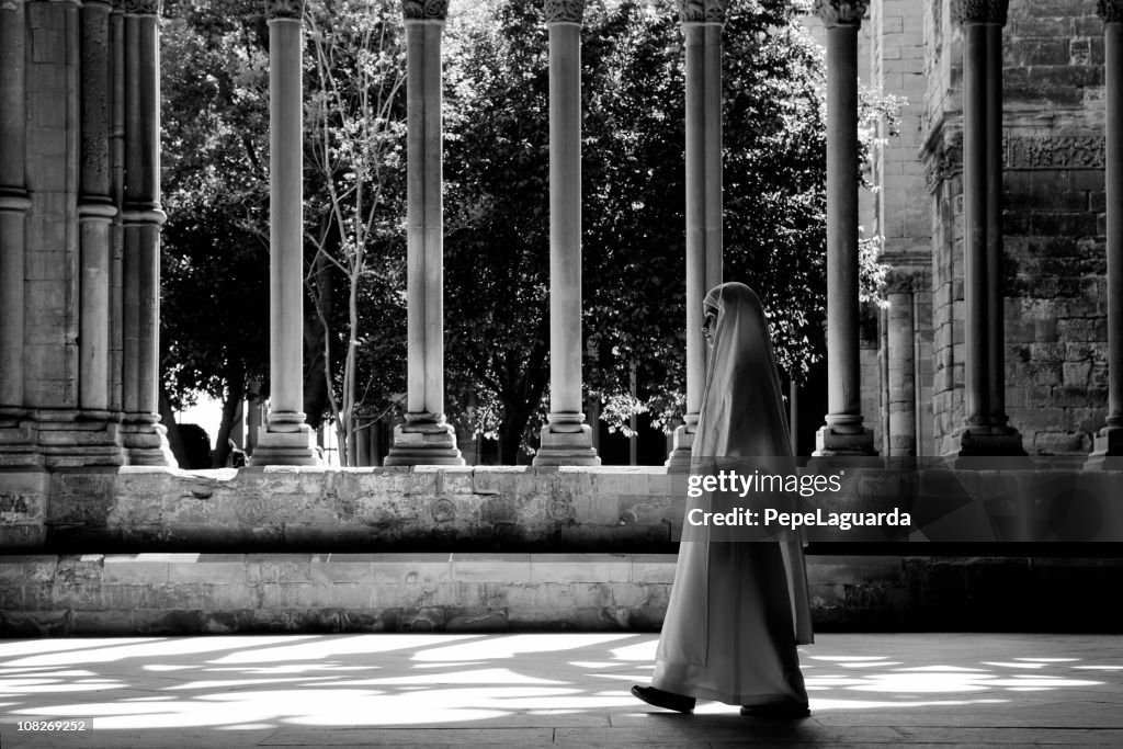 Nun Walking Through Church Cloister, Black and White