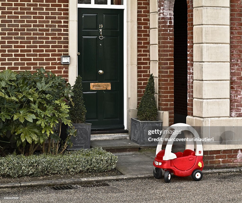 My other car's a limo!  Children's car parked house entrance