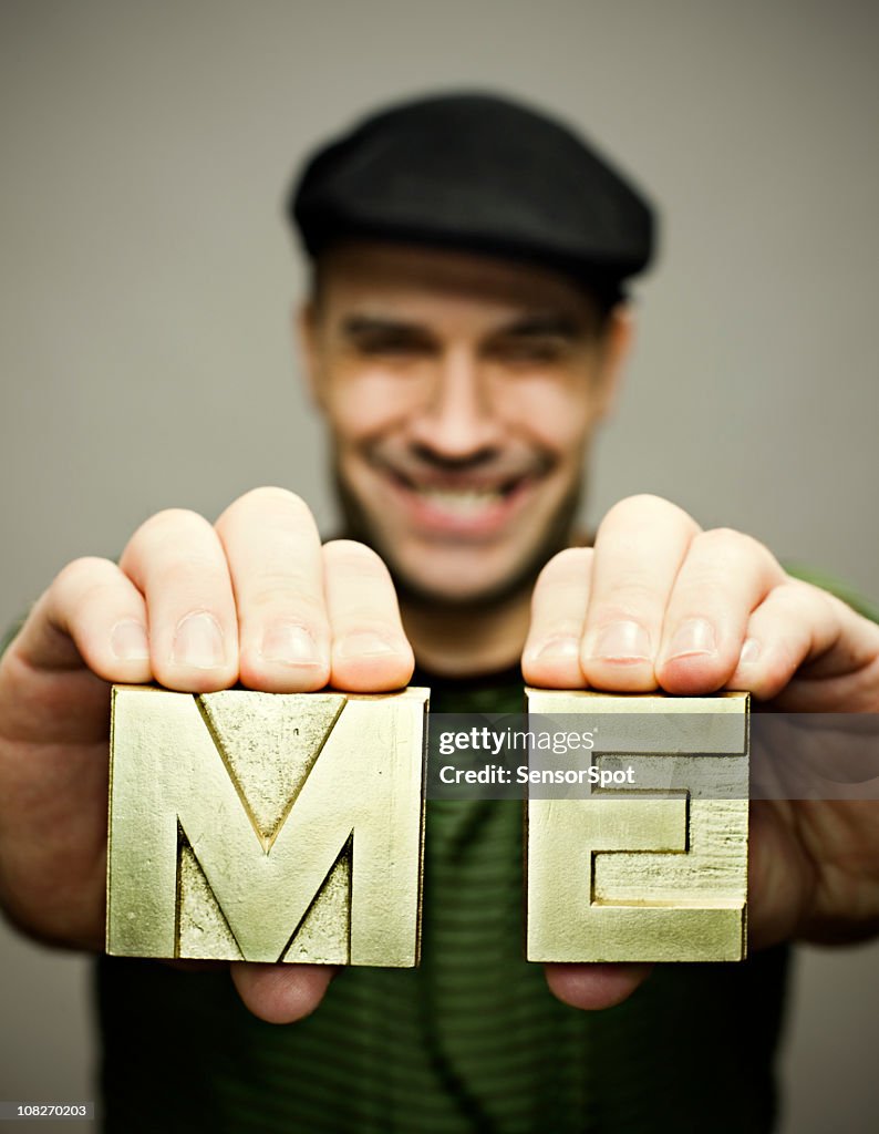 Man holding me block letters