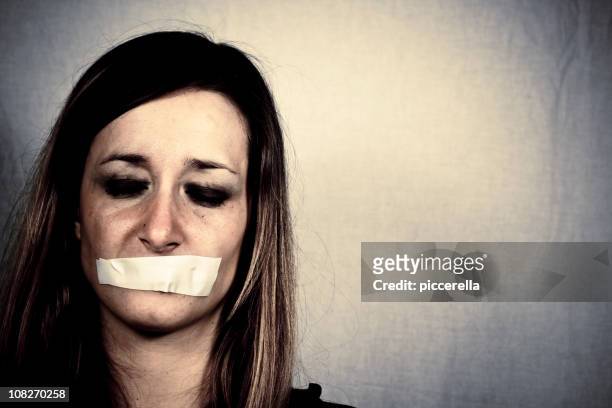 woman with tape covering mouth - female torture 個照片及圖片檔