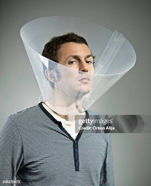 serious man wearing dog cone - hondenkraag stockfoto's en -beelden