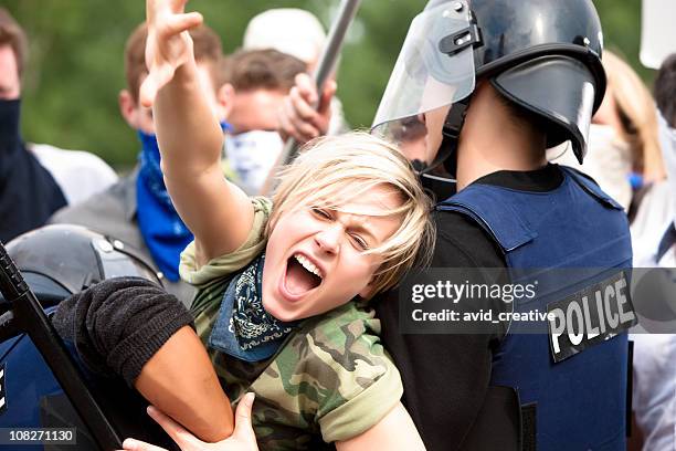 protestor trying to get through police barricade - riot stock pictures, royalty-free photos & images