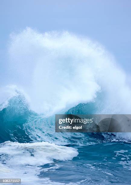 esplodere onda con bianco a spruzzo e blu cielo sfondo chiaro - onda di marea foto e immagini stock