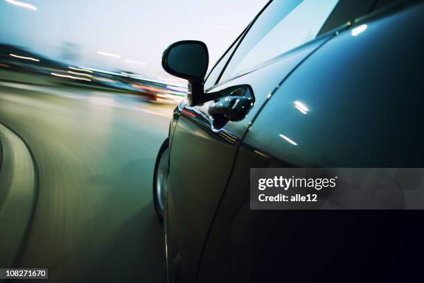 view from the side of a car going around a corner blurred - night at the net stockfoto's en -beelden