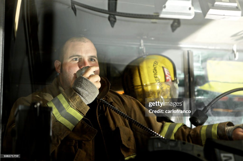 Fireman driving a truck while speaking on the radio