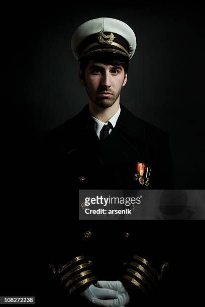 potrait of male navy ship captain, isolated on black - team captain stock pictures, royalty-free photos & images