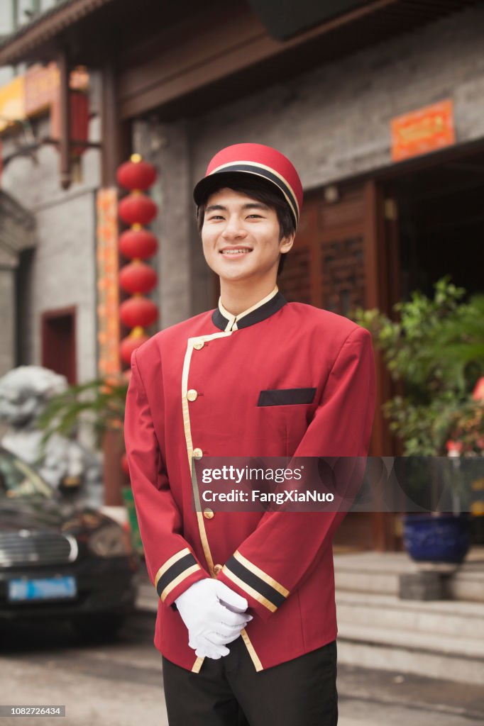 Chinese doorman smiling and looking at camera