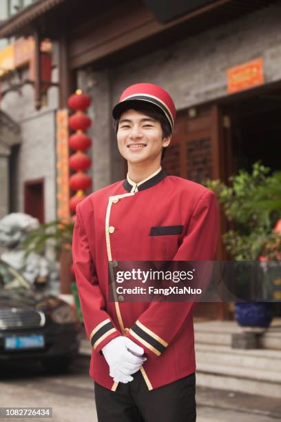 chinese doorman smiling and looking at camera - bellhop stock pictures, royalty-free photos & images