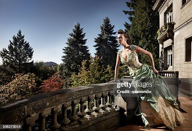 hermosa joven en vestido de noche en una mansión balcón, copyspace - una sola mujer joven fotografías e imágenes de stock