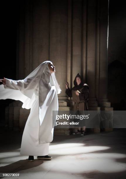 nun meditating in sunlight from cathedral window, monk watching. - nun isolated stock pictures, royalty-free photos & images