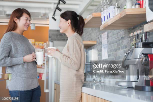 chinese businesswomen having coffee break in office kitchen - office canteen stock pictures, royalty-free photos & images