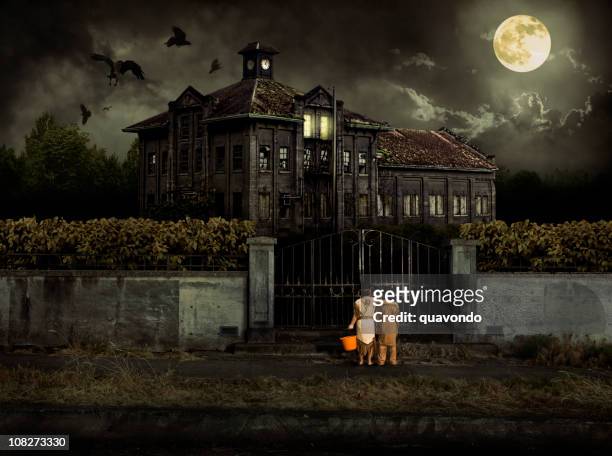 costumed kids trick or treat at halloween haunted house - spooky stock pictures, royalty-free photos & images