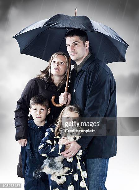 family seeking shelter from the storm - mother protecting from rain stockfoto's en -beelden