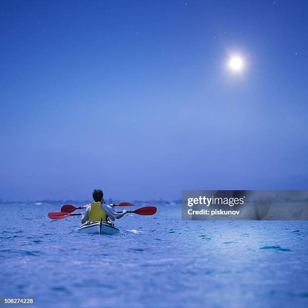 pareja joven haciendo navegación en kayak - moonlight lovers fotografías e imágenes de stock