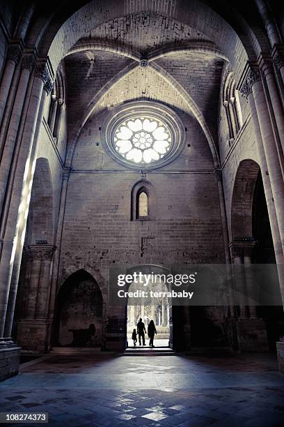 silhouette of people entering la seu vella cathedral - entering church stock pictures, royalty-free photos & images