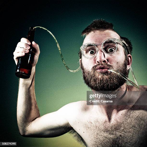 young man drinking beer out of crazy straw glasses - rietje stockfoto's en -beelden