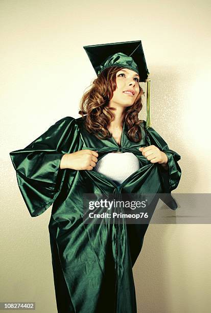 young woman graduating and showing off superhero persona - superman reveal stock pictures, royalty-free photos & images