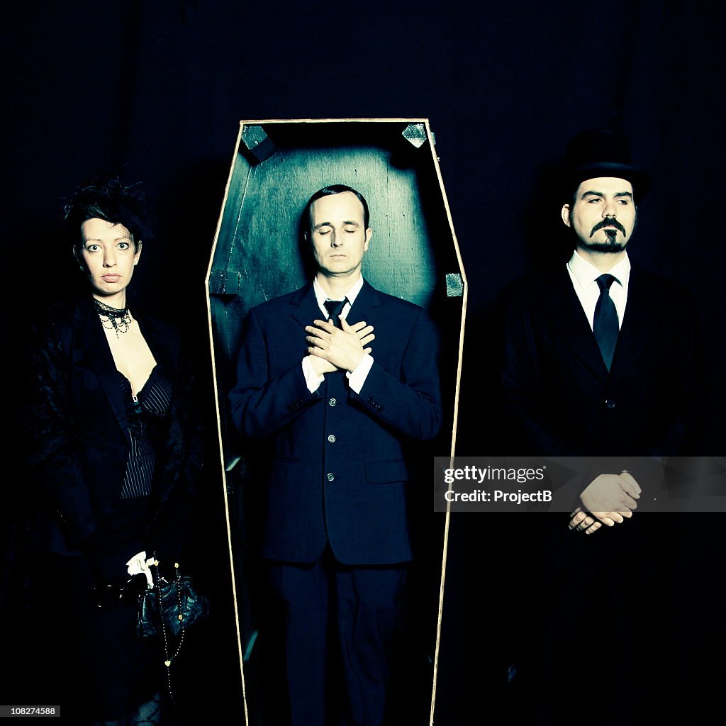 Widow, undertaker and man in coffin