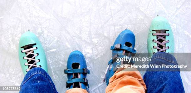 adult and child ice skates standing on ice - ice skate stock pictures, royalty-free photos & images