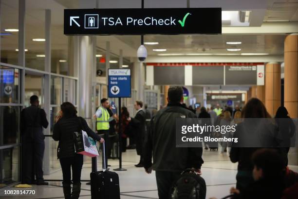 Travelers pass under a sign pointing toward a Transportation Security Administration Pre-Check checkpoint at Hartsfield-Jackson Atlanta International...