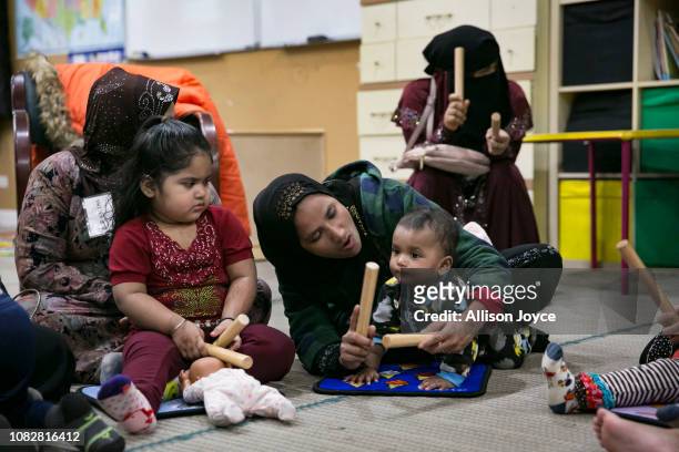 Rohingya mothers play with their children during a "Mommy and Me" class at the Rohingya Cultural Center of Chicago on January 10, 2019 in Chicago,...