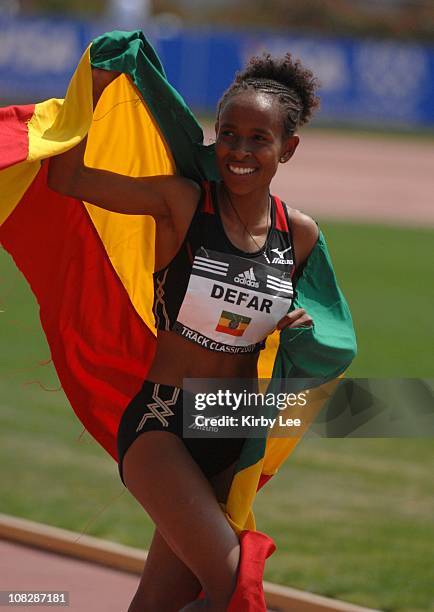 Meseret Defar of Ethiopia takes a victory lap with Ethiopian flag after winning the women's 2-mile in a world-best 9:10.47 in the adidas Track...