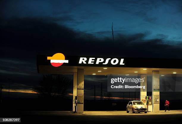 Customer returns to his vehicle after purchasing fuel at a Repsol YPF SA gas station in Tembleque, Spain, on Saturday, Jan. 22, 2011. Repsol YPF SA,...