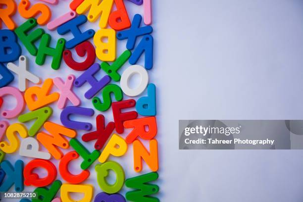 overhead view of colorful alphabets arranged on white background - abc blocks stock pictures, royalty-free photos & images