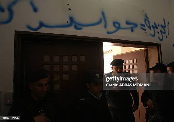 Palestinian security forces stand guard at the entrance of the Al-Jazeera offices in the West Bank city of Ramallah after some protesters stormed...