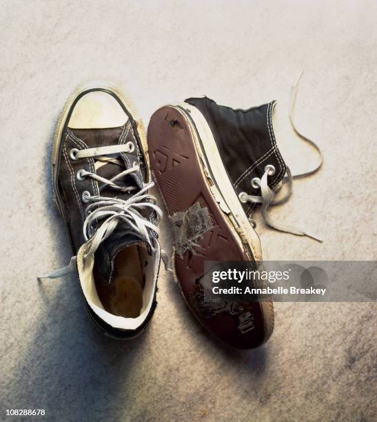 old sneakers with holes in them - old shoes stockfoto's en -beelden