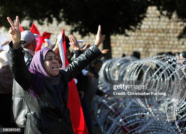 Female protester pleads with soldiers to allow her through the razor wire barricade outside the Tunisian prime minister's office on January 24, 2011...