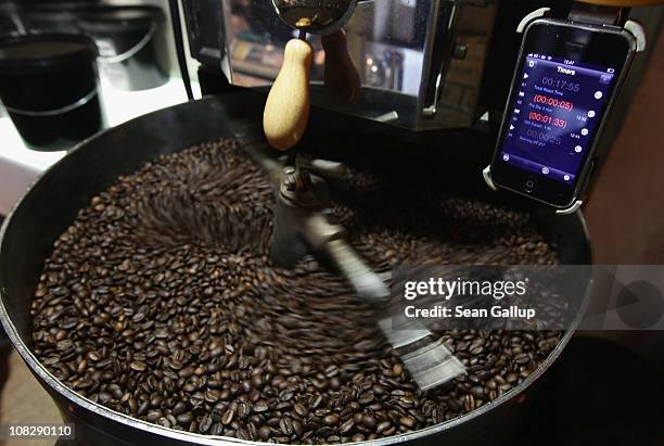 Freshly-roasted espresso coffee beans cool under an iPhone with a timer app attached to a refurbished 1918 Probat coffee bean roaster at Bonanza...