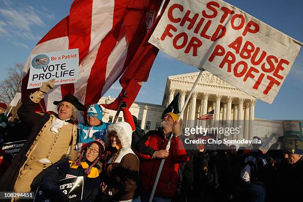 Anti-abortion demonstrators pose for photographs with a men dressed as George Washington and Captain America while they stand outside the Supreme...