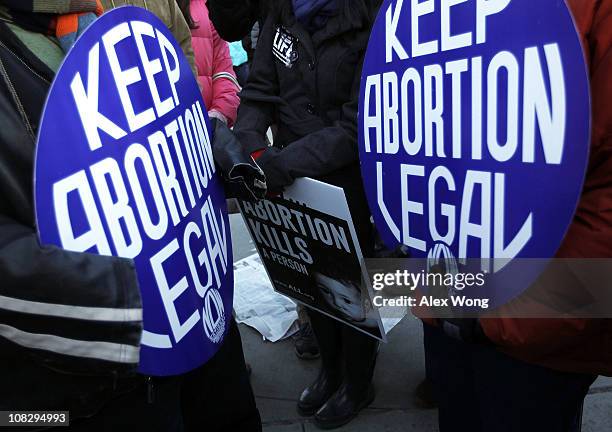 Pro-life activist stands between two pro-choice activists in front of the U.S. Supreme Court after the annual March for Life January 24, 2011 in...