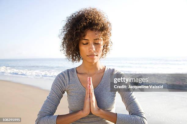 woman doing yoga on beach - concentration curl stock pictures, royalty-free photos & images