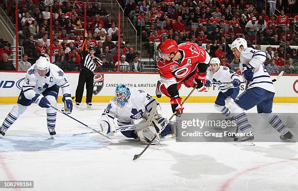 Brandon Sutter of the Carolina Hurricanes goes airbourne as he backhands the puck to score a goal past the defense of Dion Phaneuf of the Toronto...