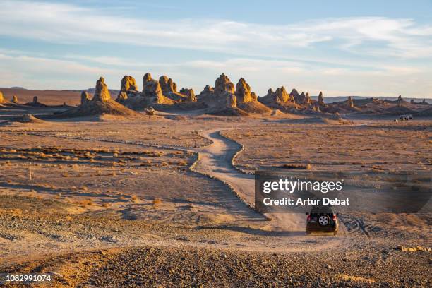 driving through the rock formations of trona pinnacles in the california desert. - pináculo formação rochosa - fotografias e filmes do acervo