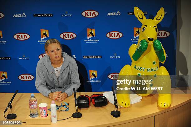 Caroline Wozniacki of Denmark speaks during a press conference next to an inflatable kangaroo and a pair of boxing gloves on the desk after she beat...