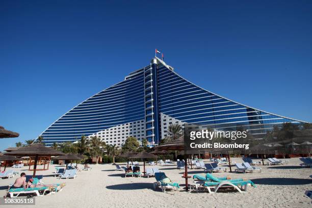 Guests are seen on sun loungers outside the Jumeirah Beach hotel, operated by the Jumeirah Group LLC, in Dubai, United Arab Emirates, on Monday, Jan....