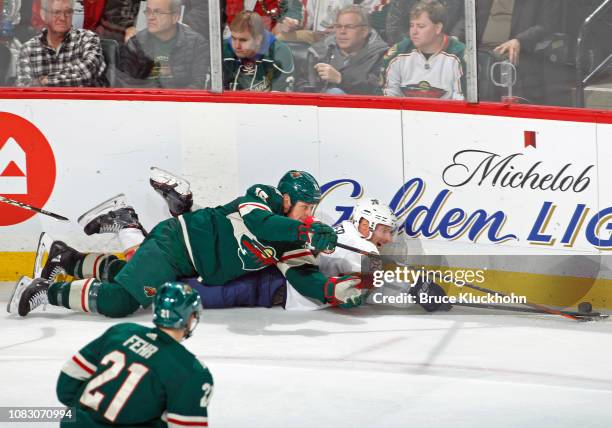 Matt Hendricks of the Minnesota Wild and Troy Brouwer of the Florida Panthers fight for the puck during a game at Xcel Energy Center on December 13,...