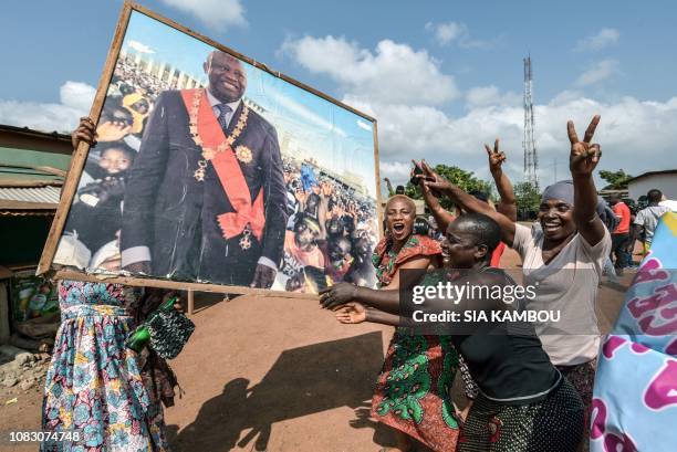 People celebrate with a portrait of former Ivory Coast president Laurent Gbagbo on January 15, 2019 in his birth-town Gagnoa after the news that...