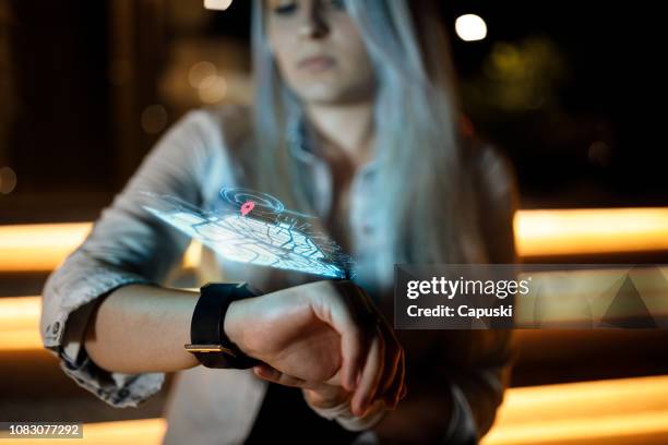 girl checking maps on virtual hologram smart watch - hologram person stock pictures, royalty-free photos & images